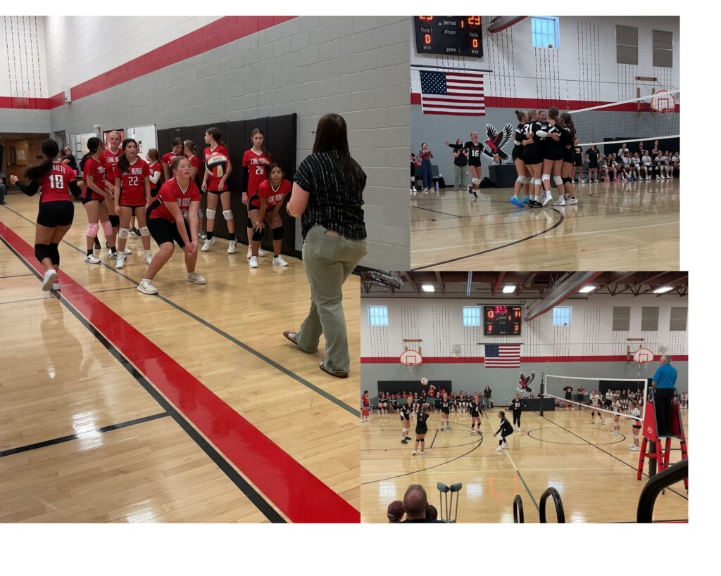 A volleyball game in progress with players in red and black uniforms, a scoreboard, and spectators in the background.