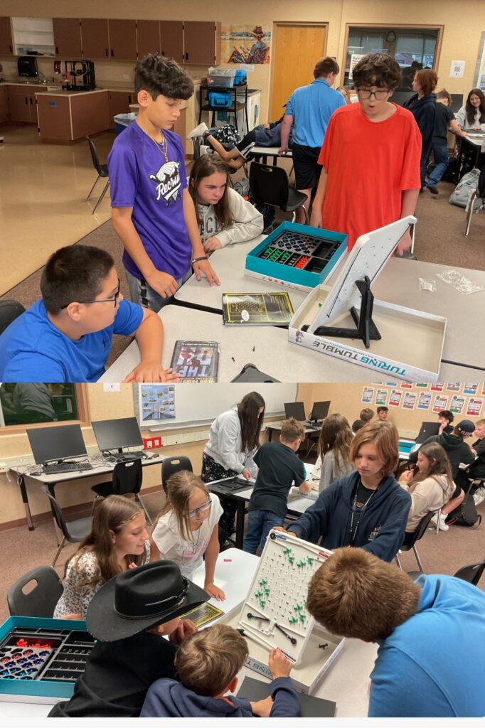 Students engaged in group activities, playing games and collaborating at tables in a classroom setting.