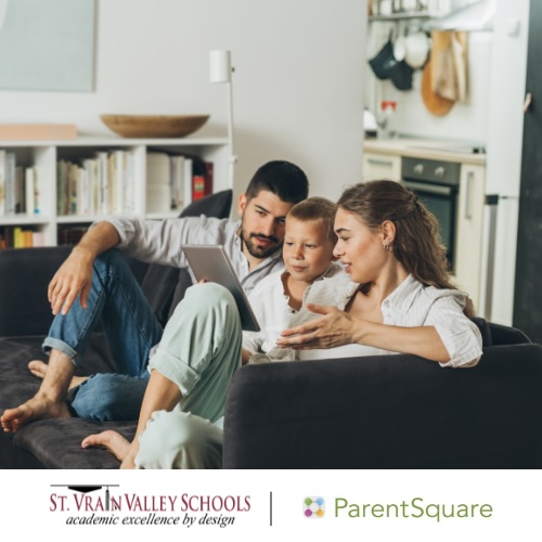 A family sits on a couch, looking at a tablet together, in a cozy living room setting.