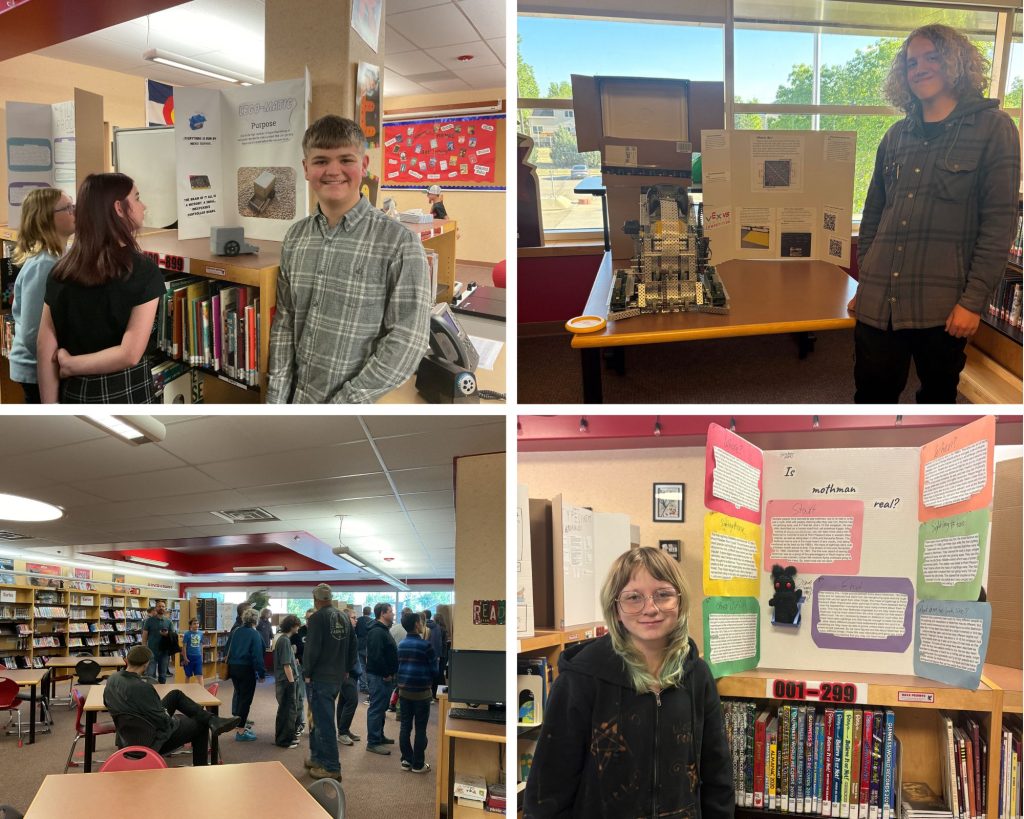 Students present projects in a library, showcasing displays on various topics and engaging with visitors.